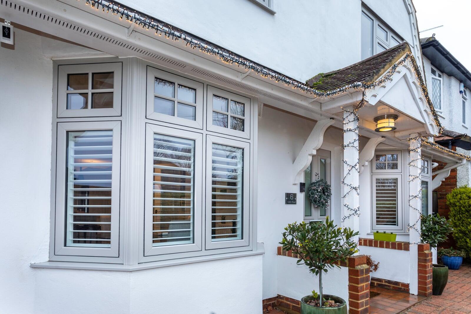 Flush casement PVC bay windows installed on a traditional white rendered home