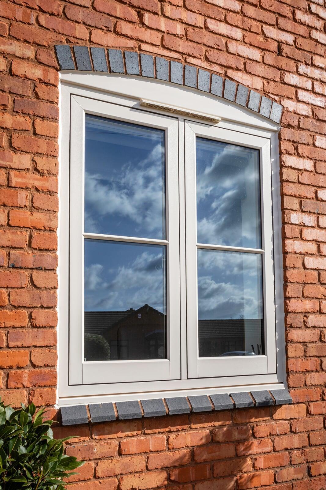 White flush casement PVC window installed in red brick exterior wall