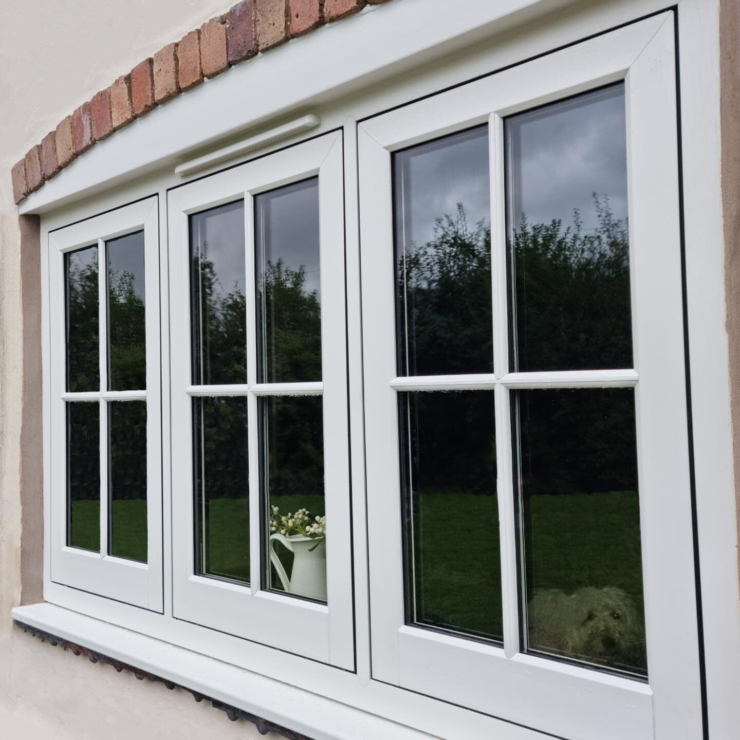 Multiple white flush casement PVC windows with Georgian bars on a modern extension