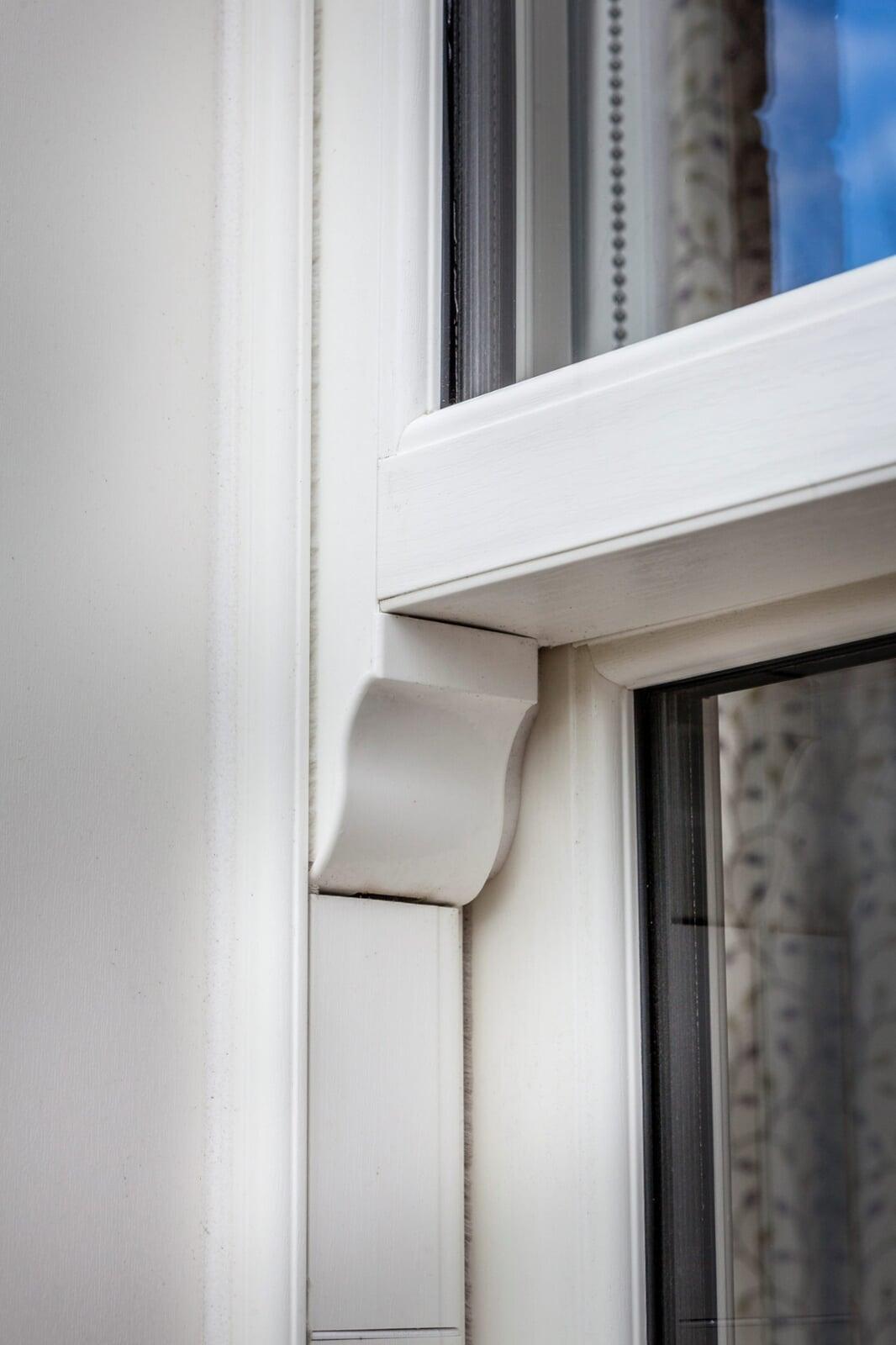 close-up of timber alternative PVC sliding sash window with decorative sash horn detail
