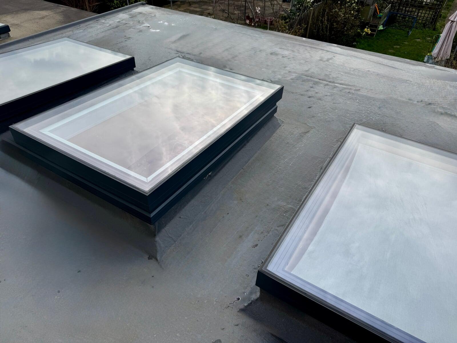 Three  flat rooflights installed on a modern flat roof with aluminium frames