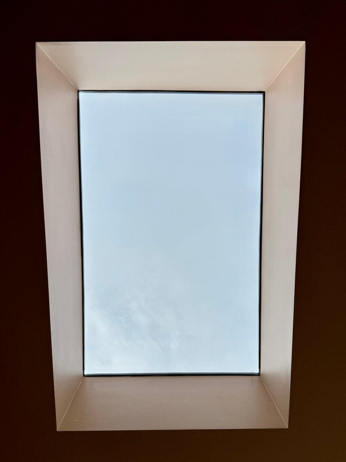 Internal view looking up through a square rooflight with plasterboard reveal