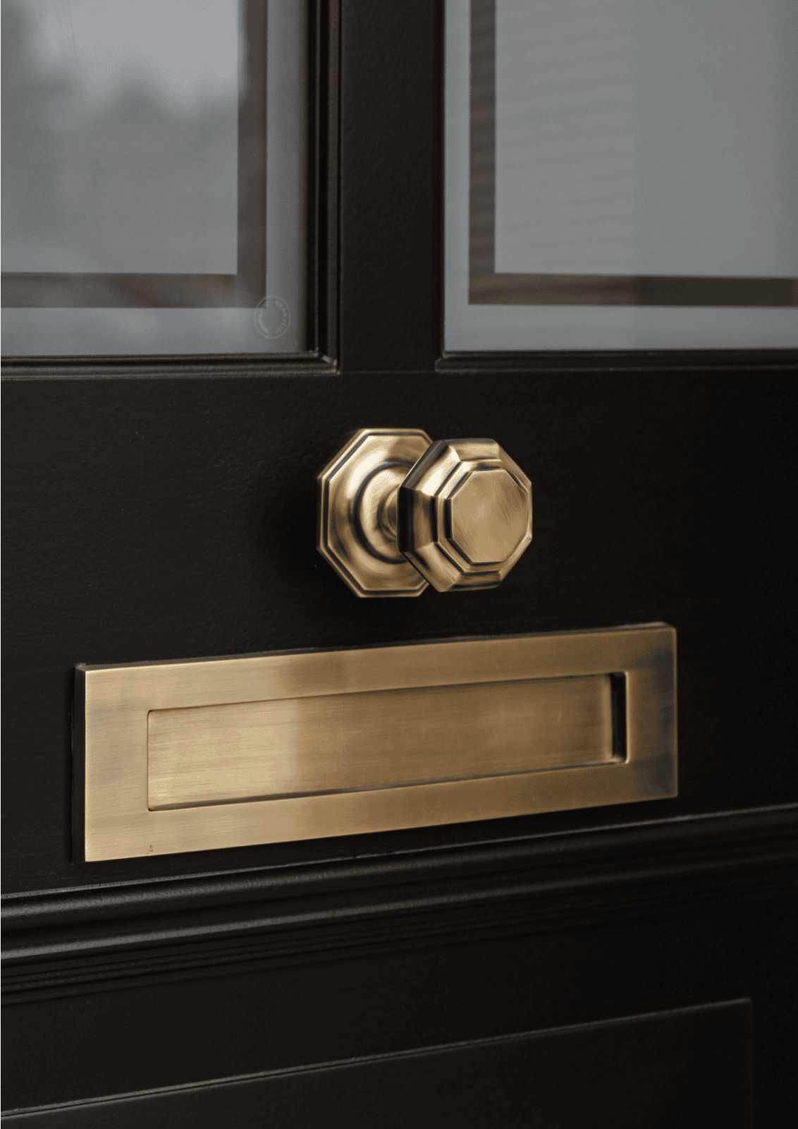 Solid brass letter plate installed on black timber entrance door
