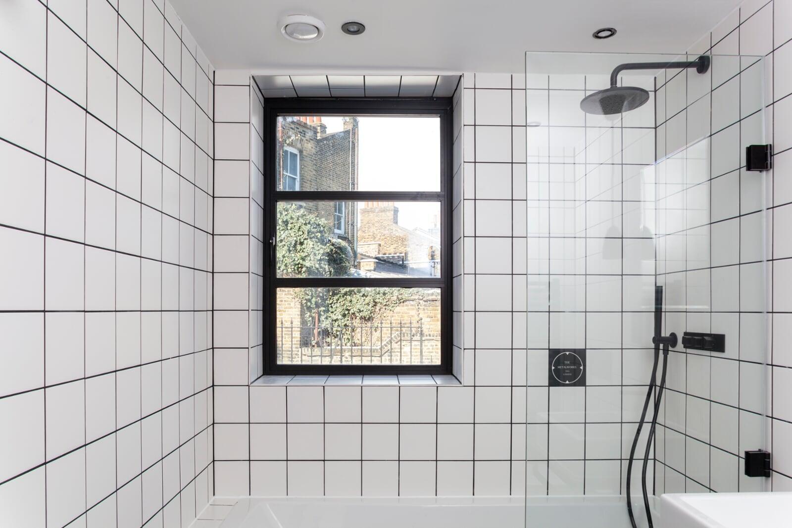 Slim black steel look aluminium window installed in contemporary bathroom