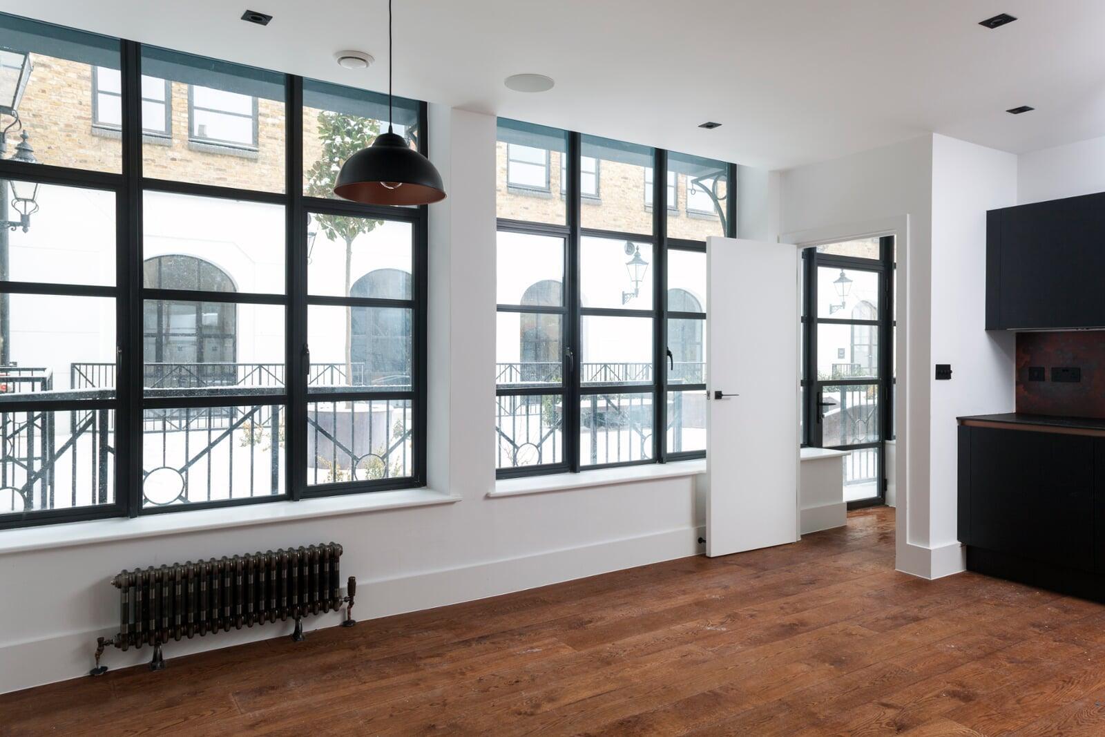 Large steel look aluminium windows with slim grid bars in contemporary living space