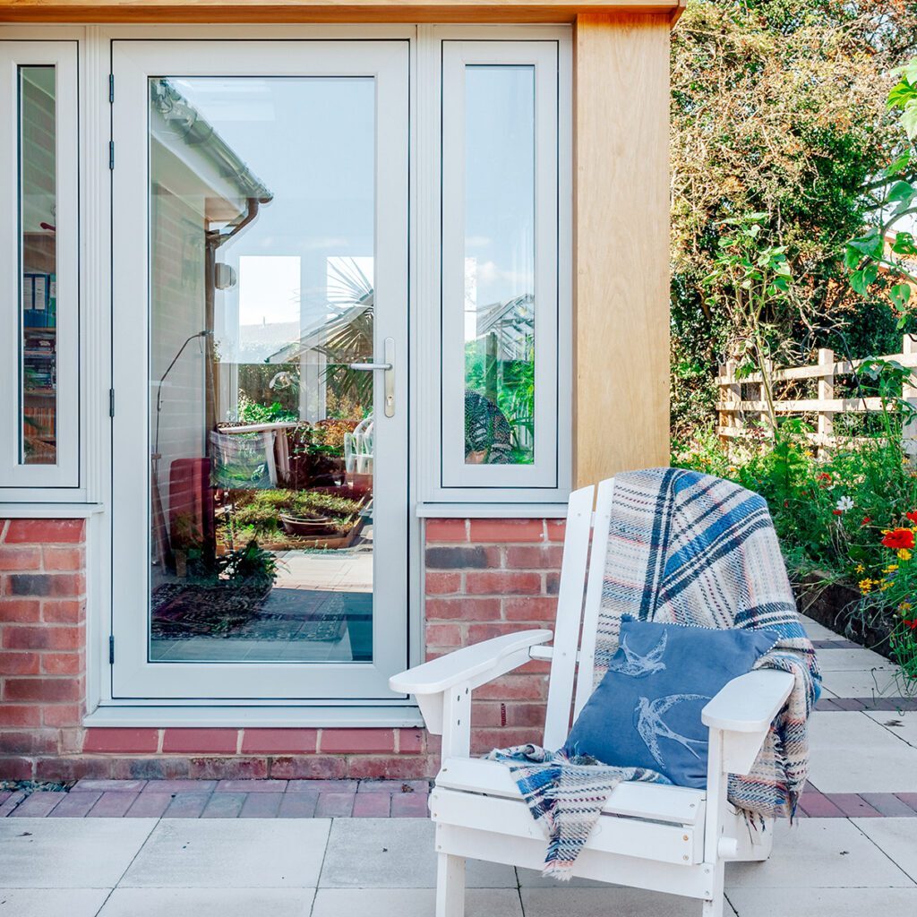 Residence RD glazed entrance door installed on modern home with side seating area