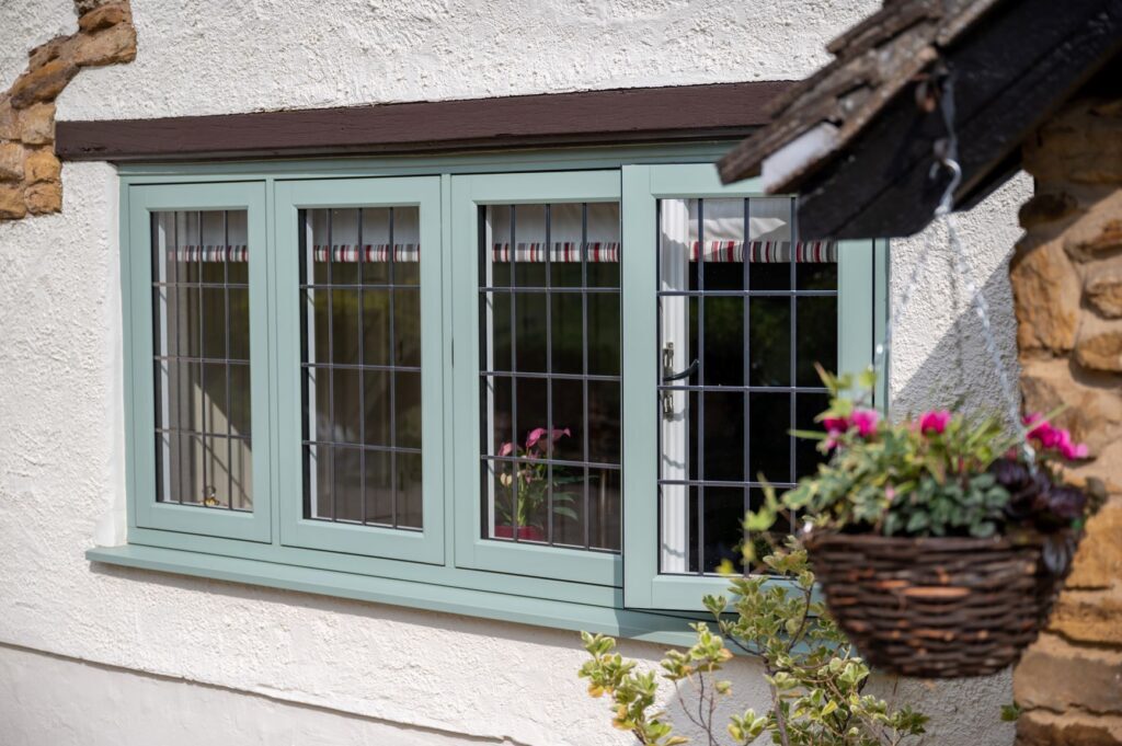 Residence Collection flush sash windows in Cotswold  green with decorative leaded glazing