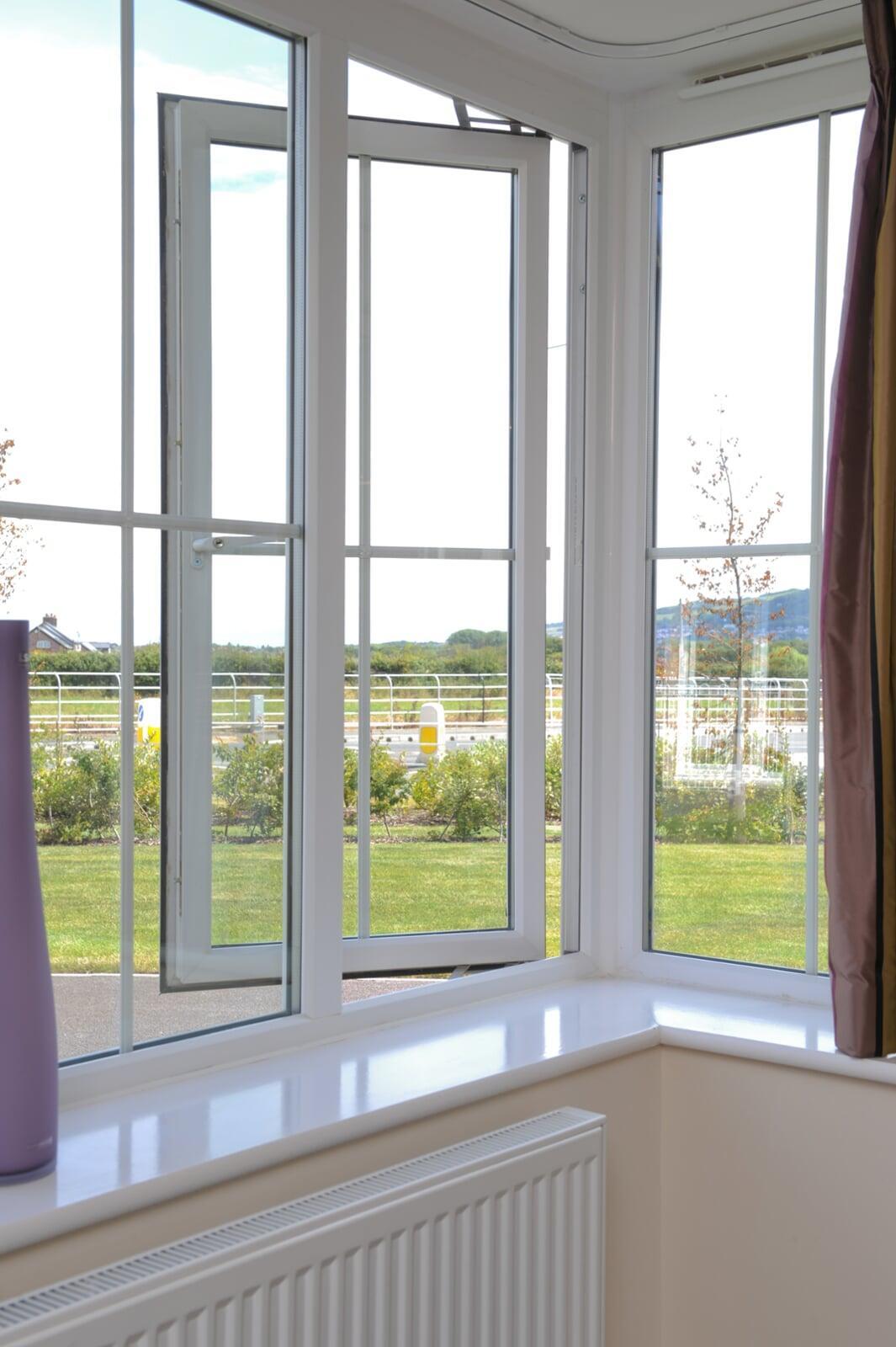 Interior view of white stormproof PVC casement window opened for ventilation