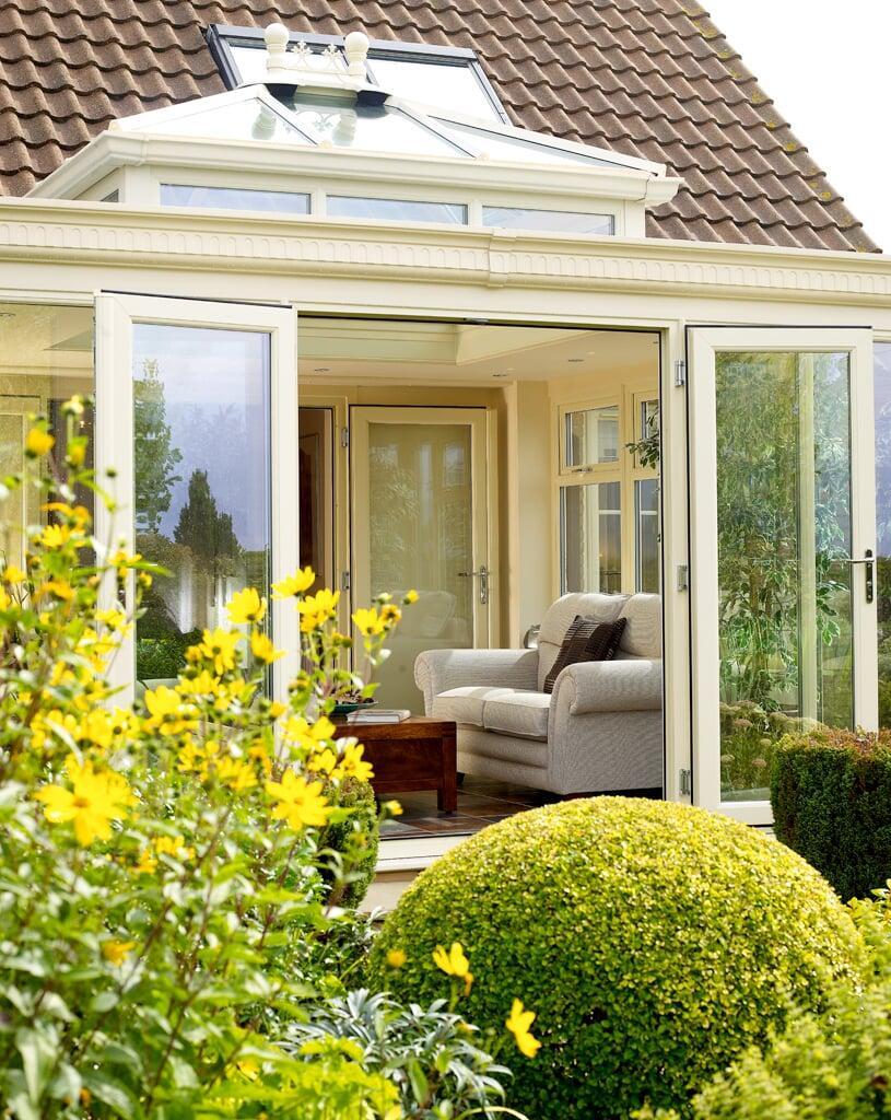 White PVC French doors opening from a conservatory into a garden