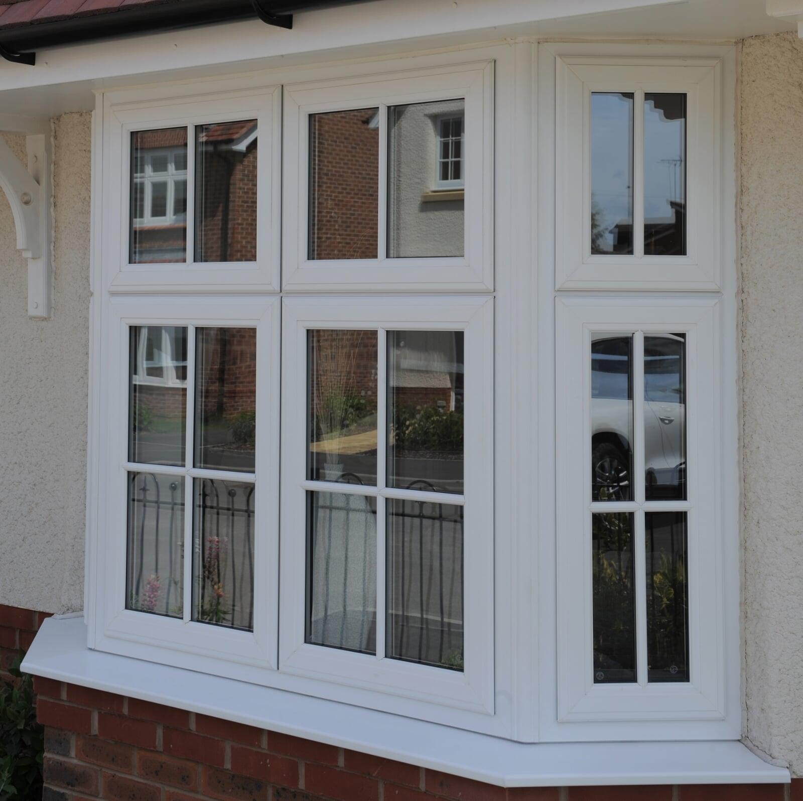 White PVC casement windows installed on traditional brick house