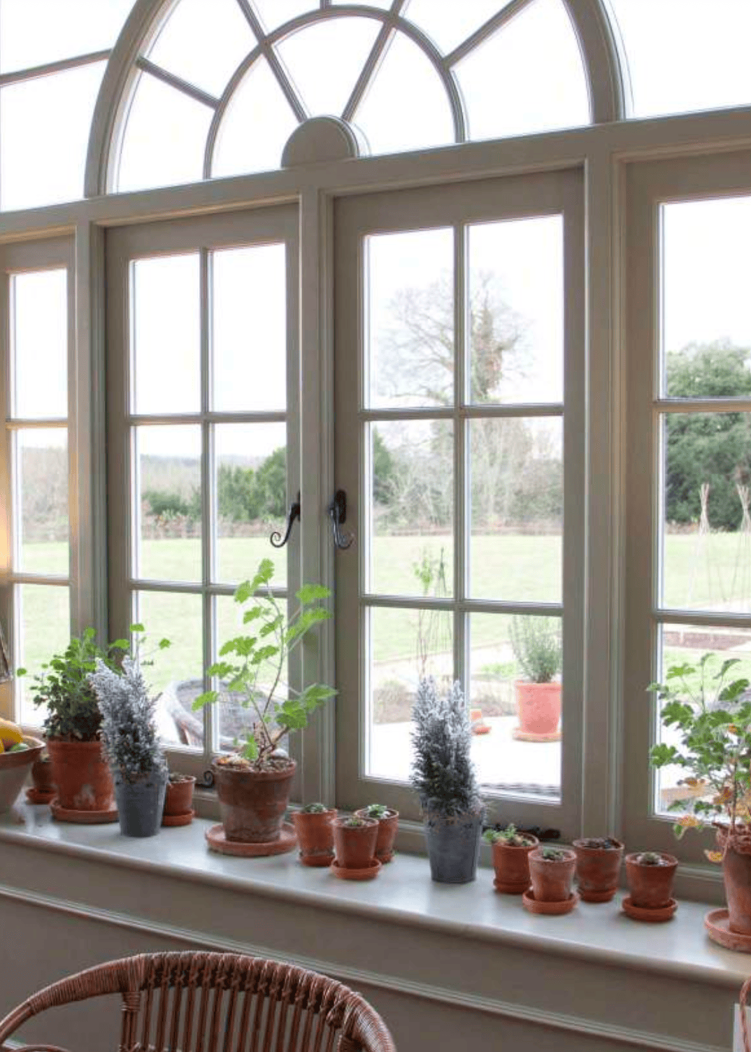 Traditional timber casement windows with arched head in classic interior setting